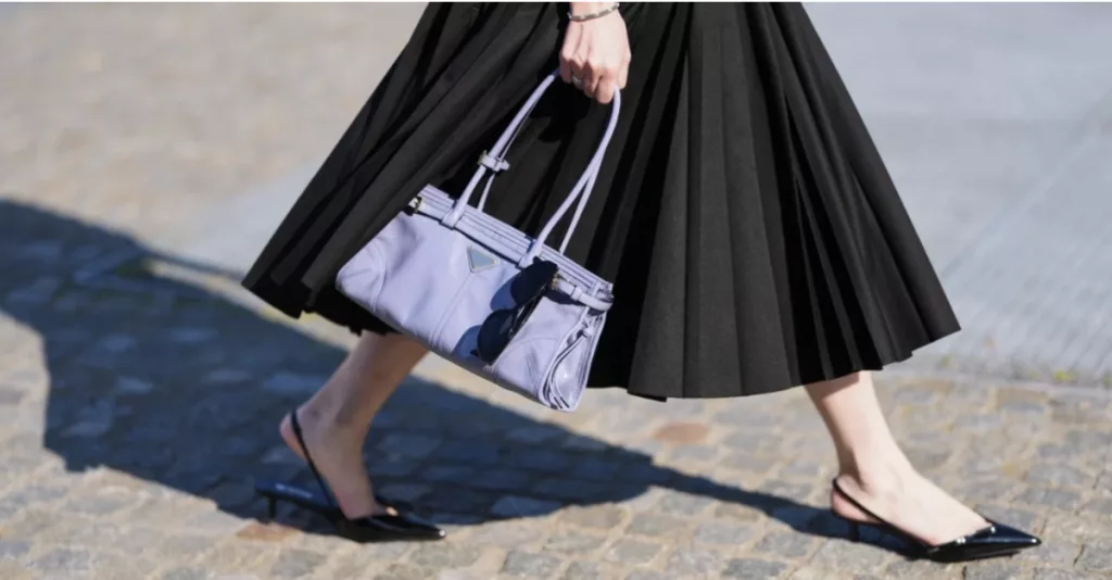 Black Prada micro kitten heels styled with a pleated skirt