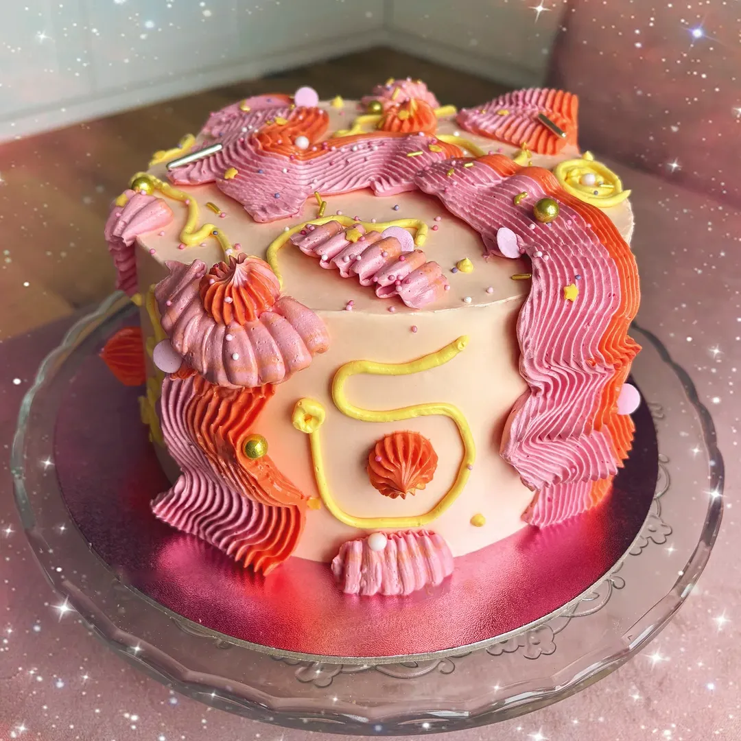 Colourful squiggle cake decorated with broad bands of closely piped buttercream