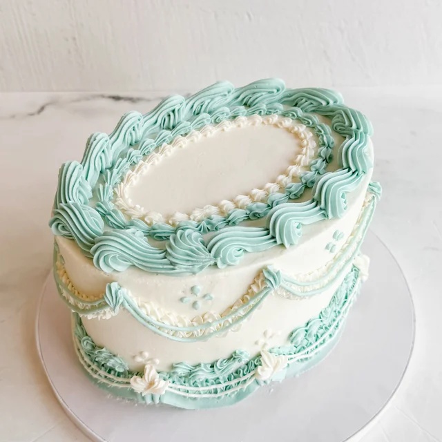 Pastel oval cake decorated with vintage-style piped borders
