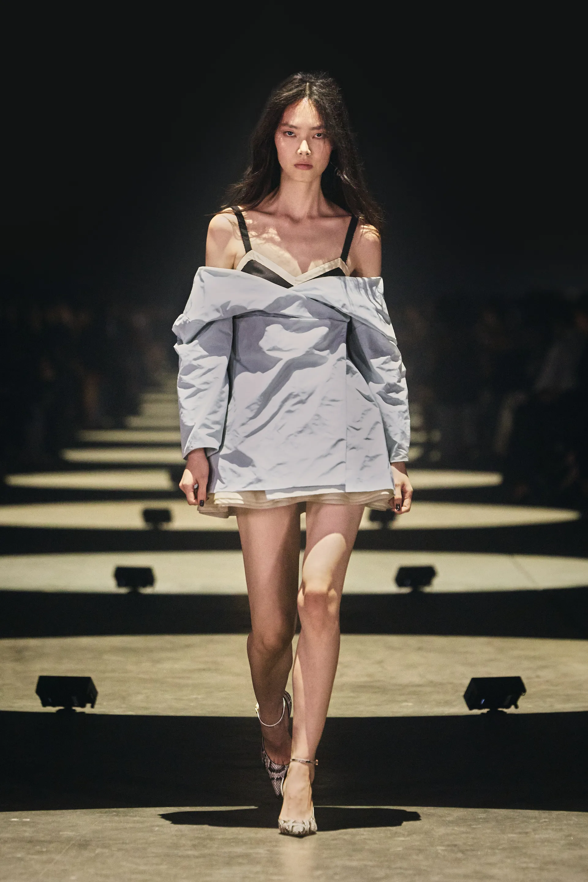 Khaite Spring 2027 bra visible beneath oversized pale outerwear