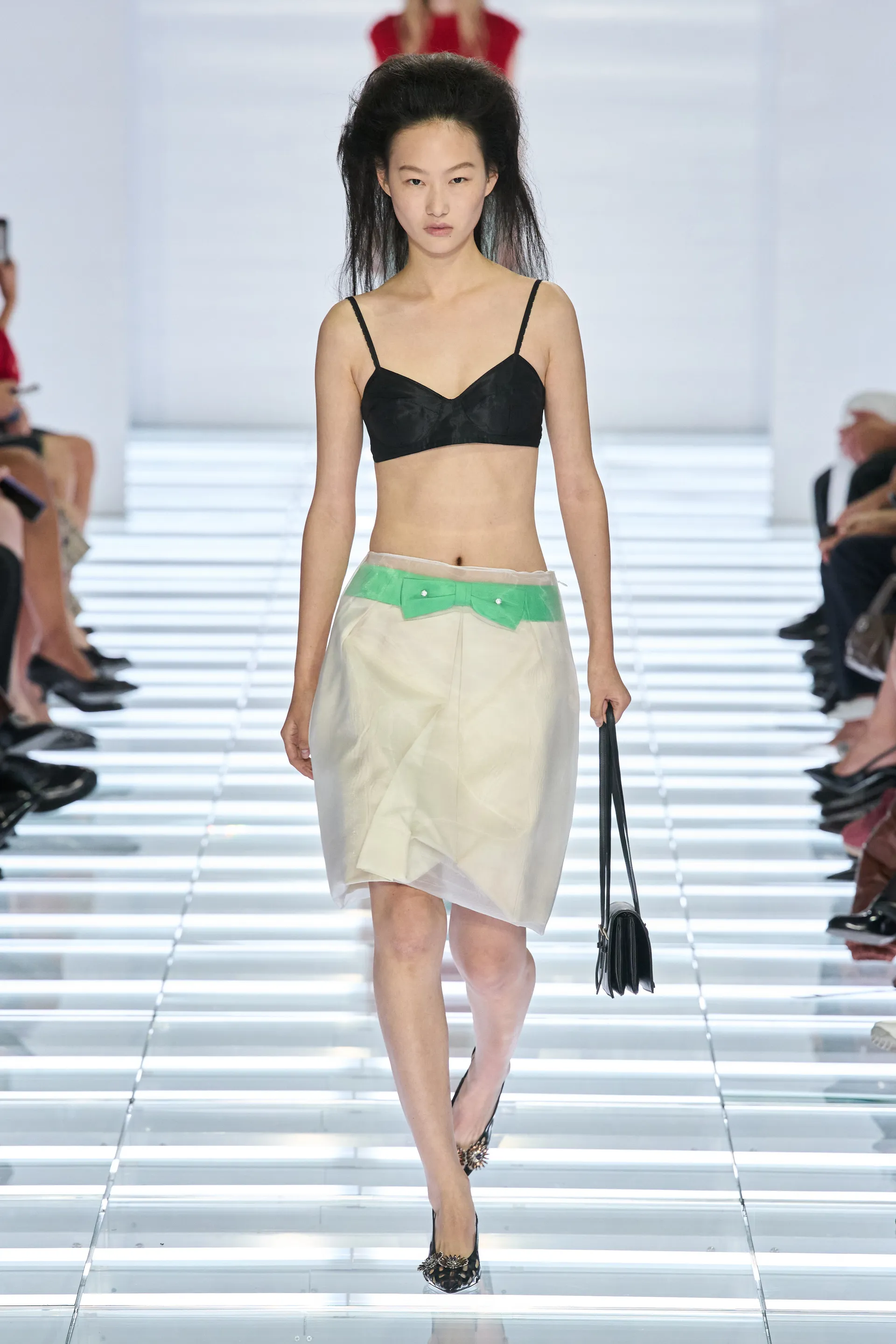 Prada Spring 2027 black bra paired with a pale semi-sheer skirt