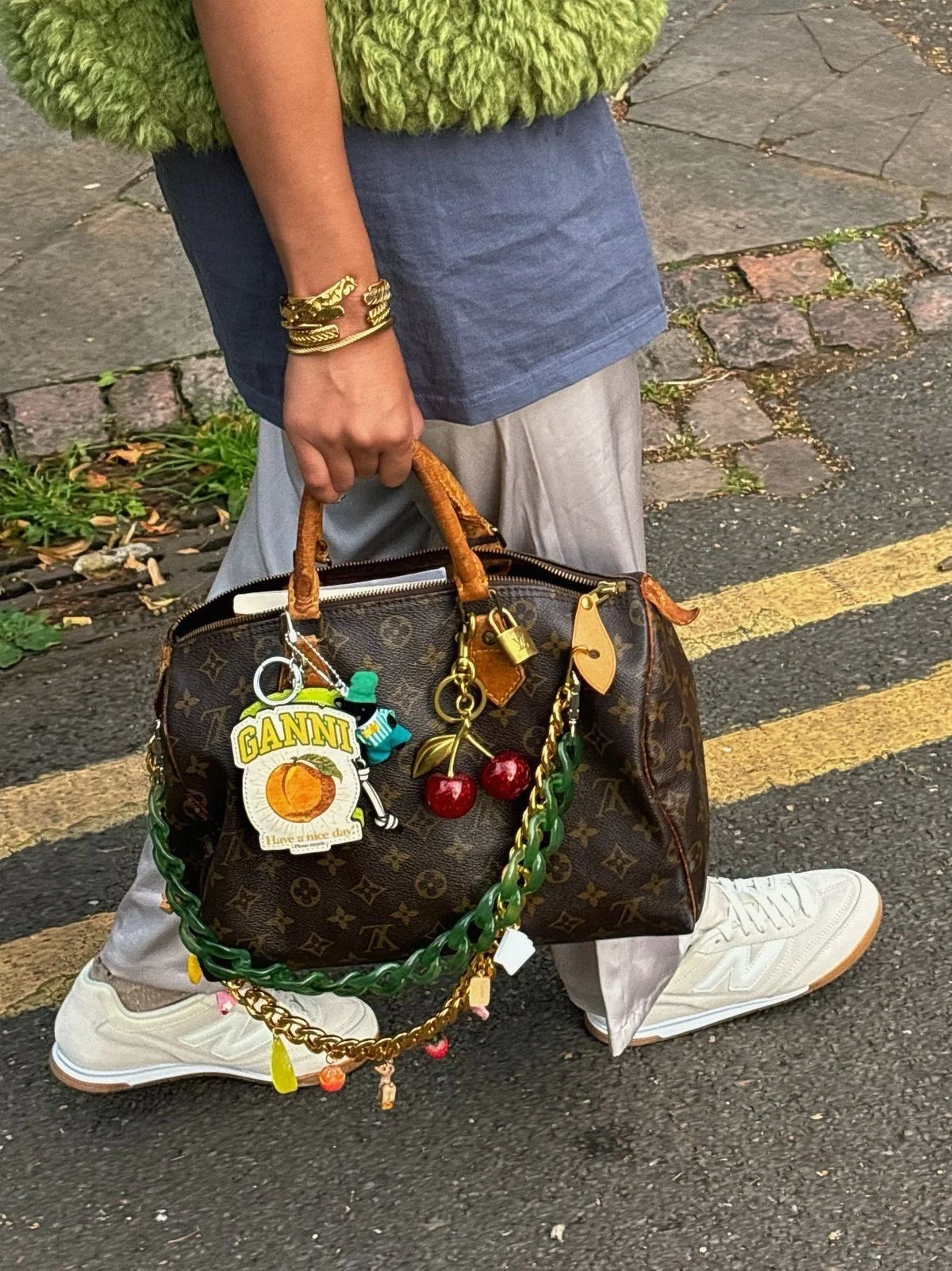 Louis Vuitton Speedy bag styled with cherry, gold, and peach charms