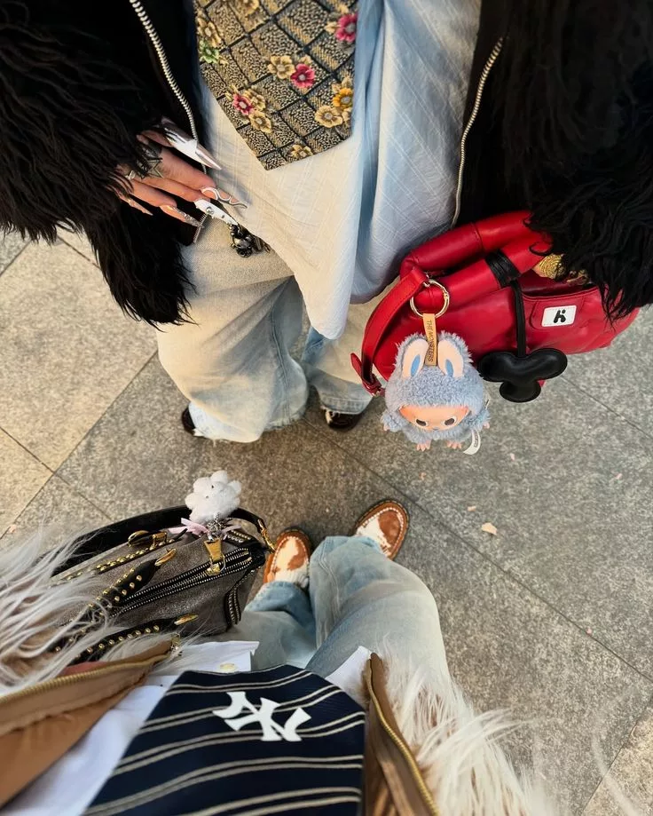 Close-up of Labubu Toy Fashion Accessory plush on red crossbody bag styled with floral fashion