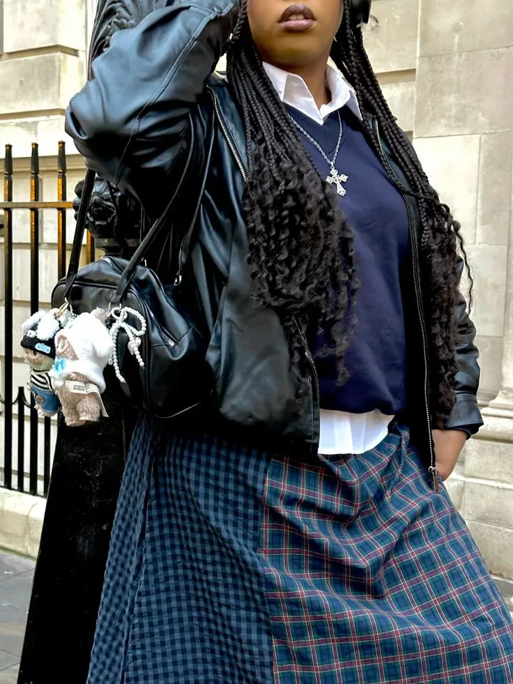 Labubu Toy Fashion Accessory on black handbag worn by fashion-forward woman in check skirt